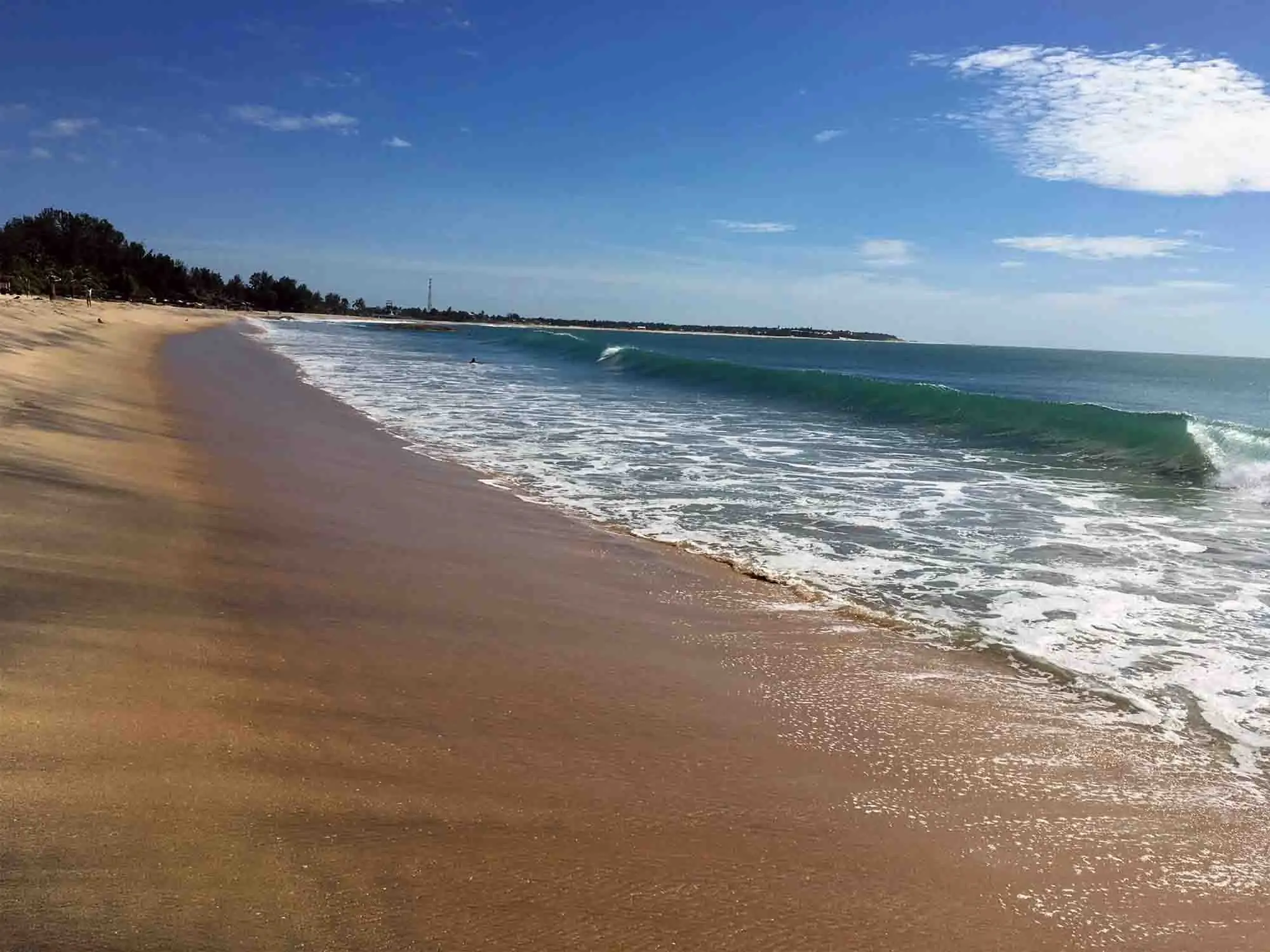 Surfers catching peeling waves in Arugam Bay